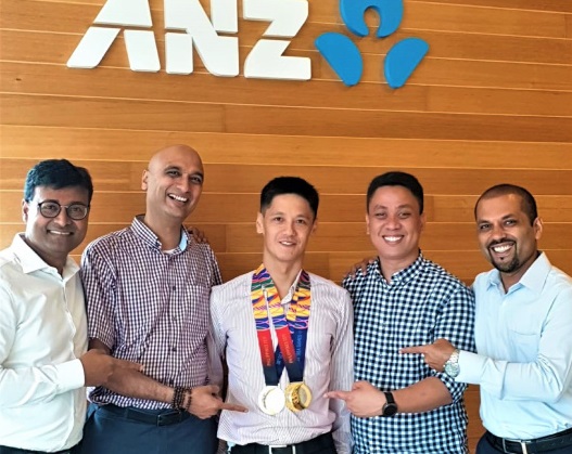 Simon (middle) and his very excited/proud colleagues at ANZ with the gold medals